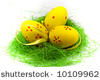 Three yellow easter eggs with green grass isolated on white