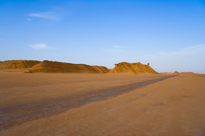 Path over hot Sahara desert blue sky